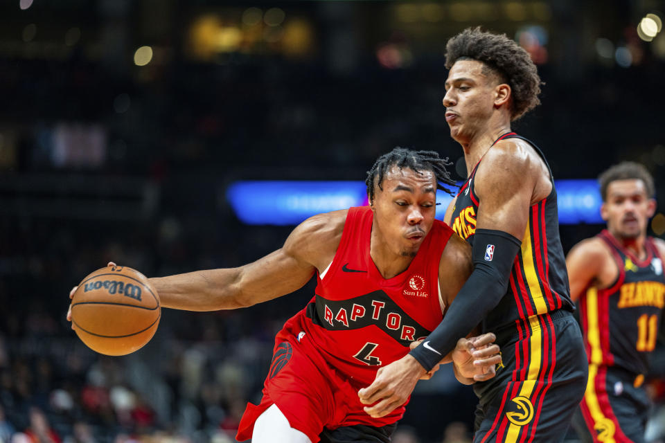 Toronto Raptors forward Scottie Barnes (4) drives the lane while being guarded by Atlanta Hawks forward Jalen Johnson (1) during the first half of an NBA basketball game Friday, Feb. 23, 2024, in Atlanta. (AP Photo/Jason Allen)