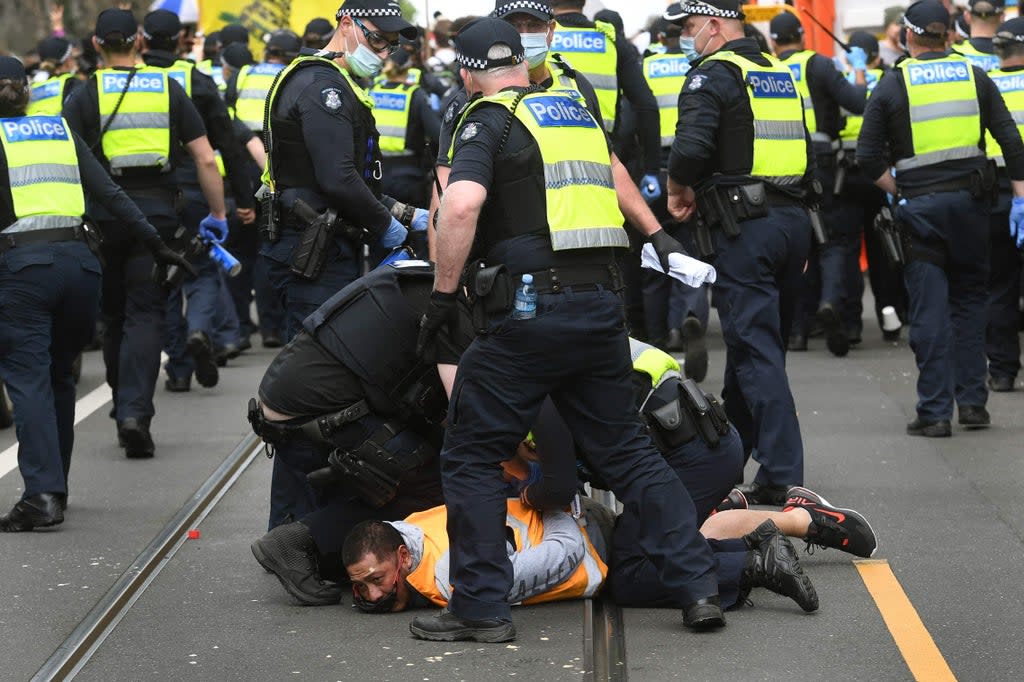 Police arrest a protester during an anti-lockdown rally in Melbourne (AFP via Getty Images)