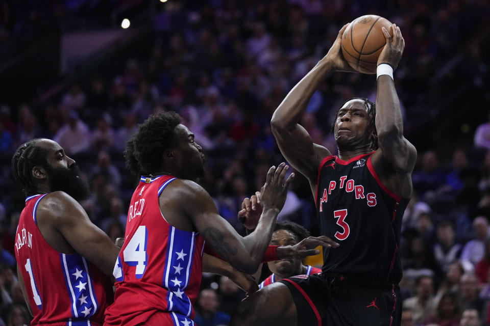 Toronto Raptors' O.G. Anunoby (3) goes up to shoot against Philadelphia 76ers' James Harden (1) and Paul Reed during the first half of an NBA basketball game, Friday, March 31, 2023, in Philadelphia. (AP Photo/Matt Rourke)