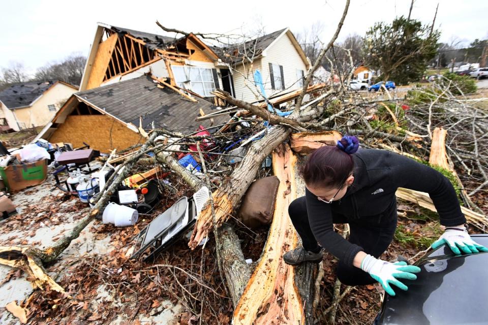 A resident climbs over debris after her friend's home was lifted off its foundation on Sunday (Copyright 2023 The Associated Press. All rights reserved)