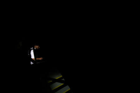 People use light from phones while they walk at the staircase of a building during a blackout in Caracas, Venezuela March 25, 2019. REUTERS/Carlos Garcia Rawlins