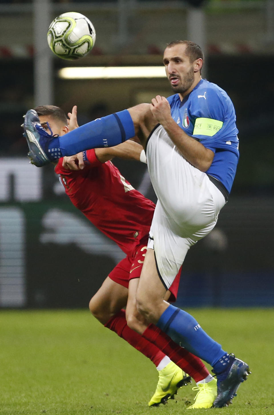 Portugal's Andre Silva, left, and Italy's Giorgio Chiellini fight for the ball during the UEFA Nations League soccer match between Italy and Portugal at the San Siro Stadium, in Milan, Saturday, Nov. 17, 2018. (AP Photo/Antonio Calanni)