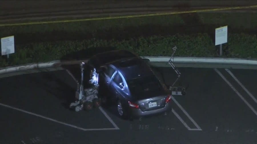 Robots inspect a vehicle possibly belonging to the suspect on March 26, 2024. (KTLA)