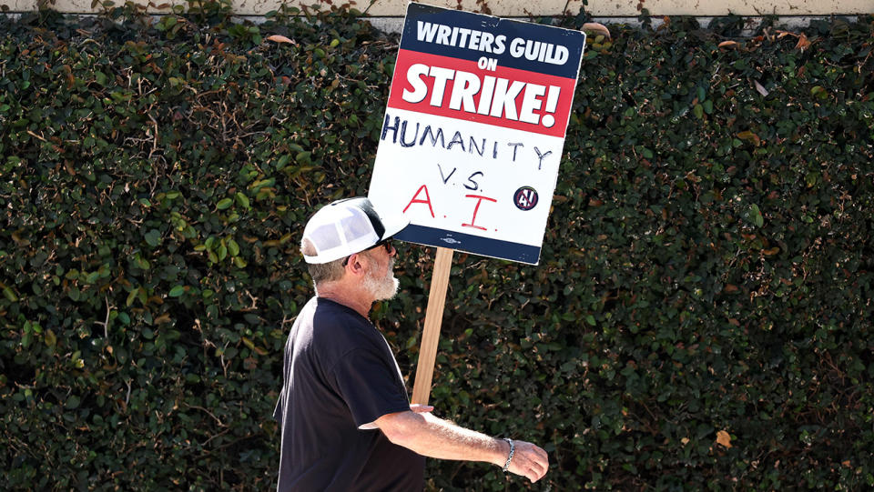 A WGA sign reads 'Humanity vs. AI' as striking members picket outside Warner Bros. Studio on August 16, 2023 in Burbank, California.