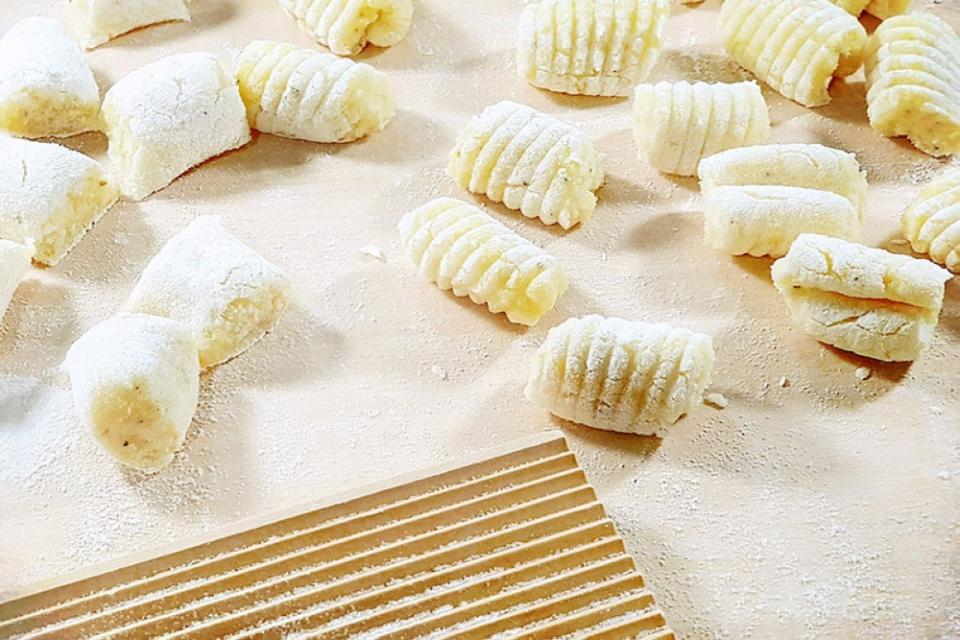 Rolling bouncy gnocchi using a traditional 'rigagnocchi' (wooden gnocchi board).