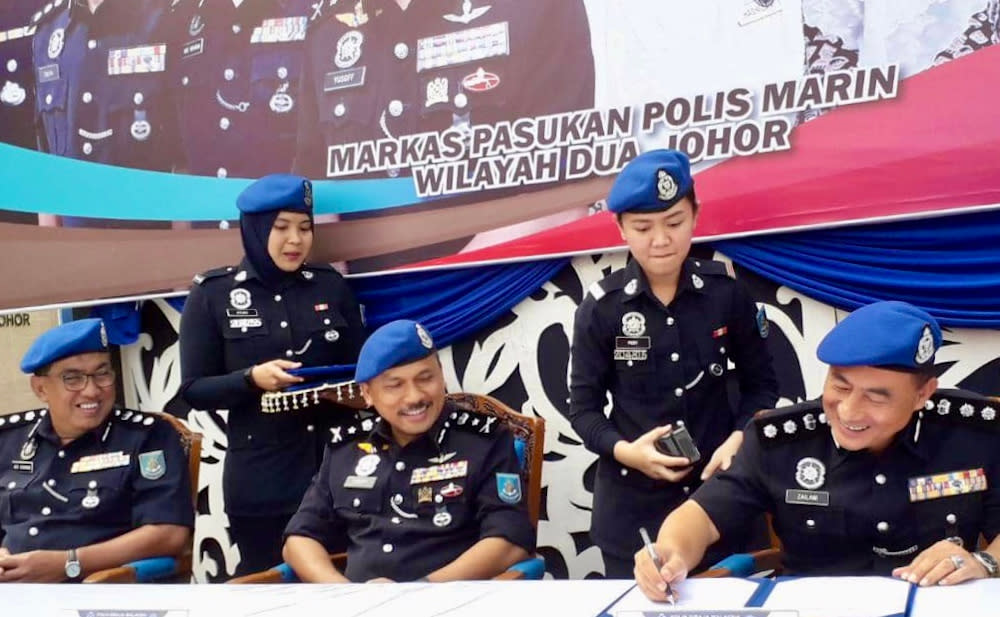 Federal marine police force commander SAC Mohd Yusoff Mamat (centre) witnesses the signing and handing over of duties by outgoing Region Two marine police commander Assistant Commissioner Abdul Rahman Mohamad (left) to Assistant Commissioner Muhd Zailani Abdullah at the Region Two marine police base in Pengkalan Rinting in Tampoi, Johor Baru today. — Picture by Ben Tan