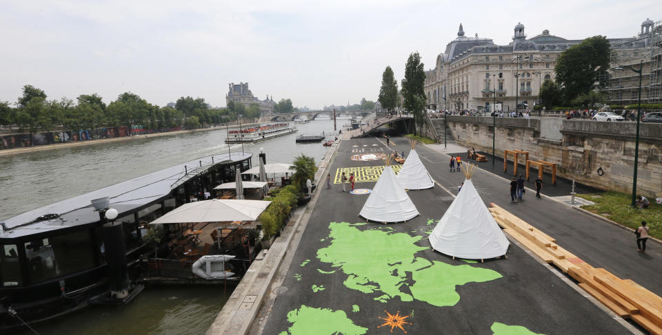 People stroll along the Left Bank of the River Seine in Paris where a new promenade has been inaugurated, Wednesday, June 19, 2013. The 2.3 km (1.4 miles) walkway offers gardens, cafes, culture and sports activities. (AP Photo/Jacques Brinon)