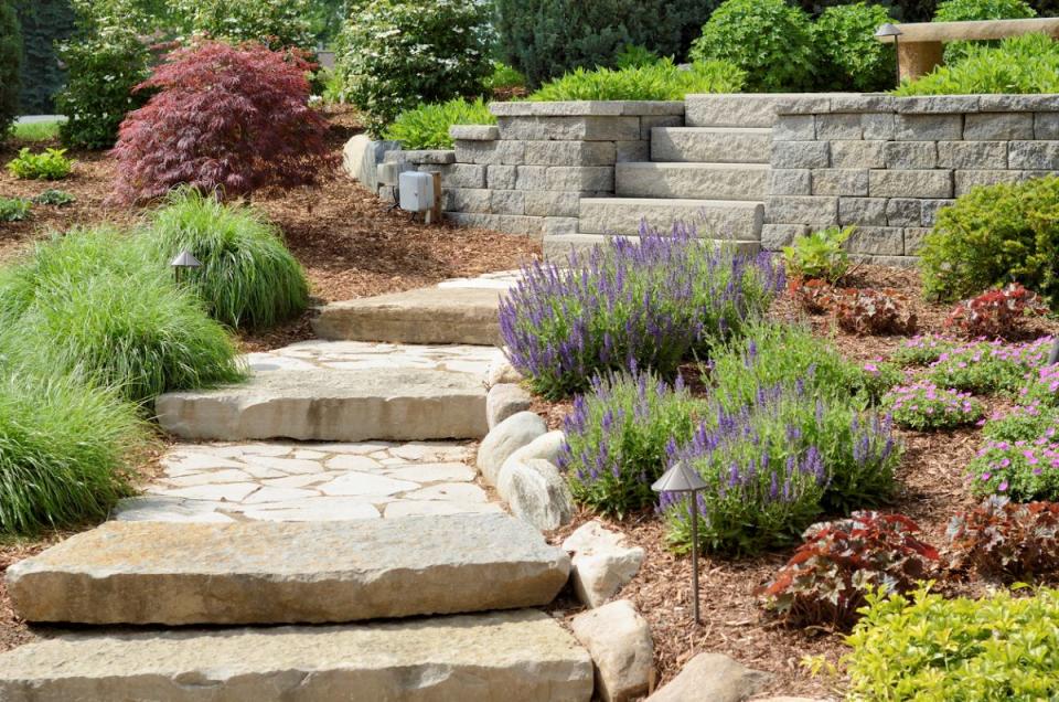 Hardscaped steps and retaining wall surrounded with ornamental plants