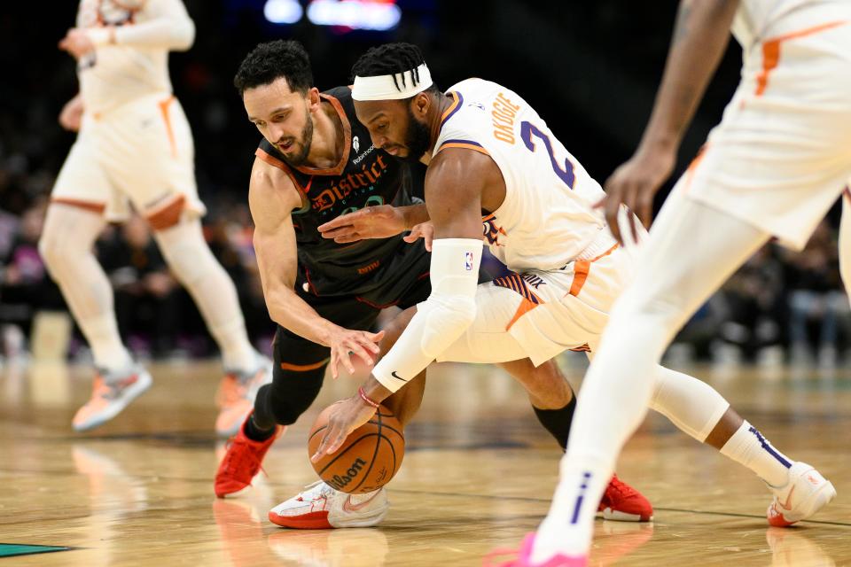 Washington Wizards guard Landry Shamet, left, and Phoenix Suns forward Josh Okogie (2) battle for the ball during the first half of an NBA basketball game, Sunday, Feb. 4, 2024, in Washington.