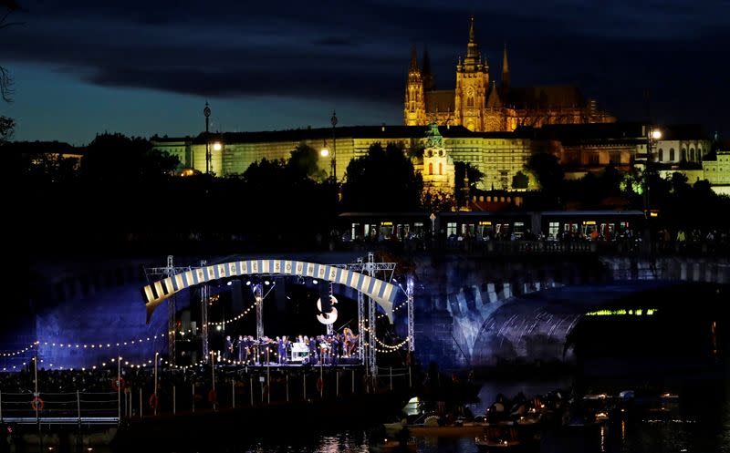 People watch a classical concert on a floating stage in Prague