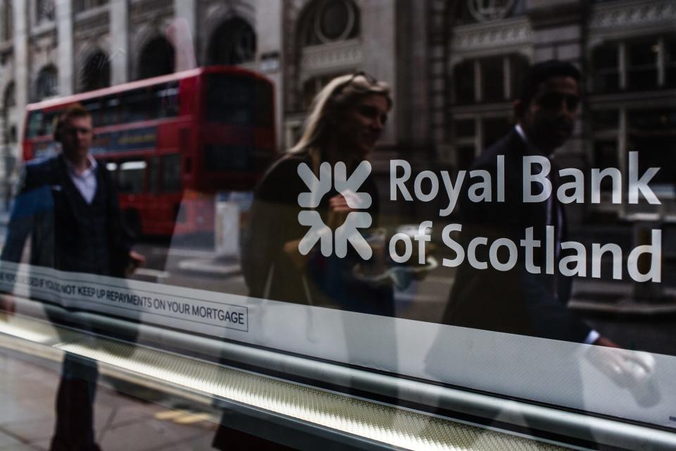 People, seen in reflection, walk past a branch of the Royal Bank of Scotland (RBS) on Threadneedle Street in London, England, on July 26, 2019.