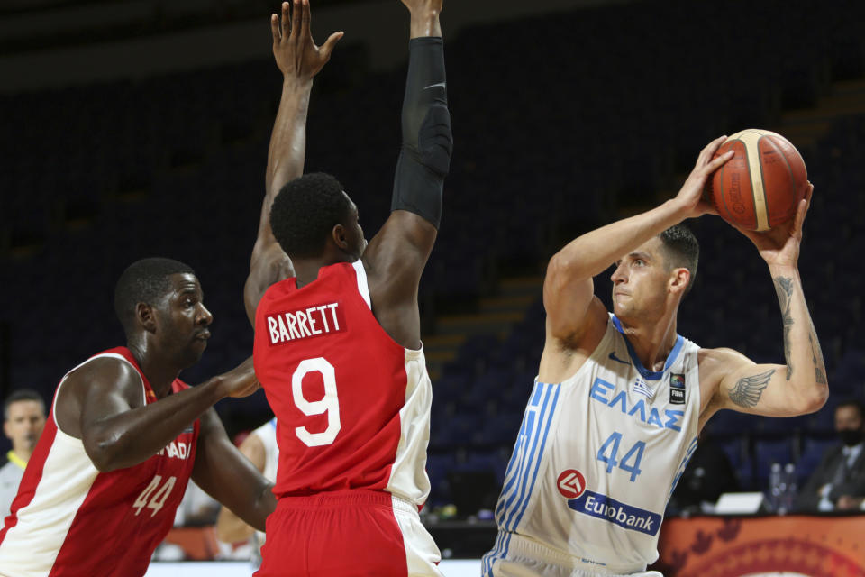 Canada's Andrew Nicholson, left, and teammate RJ Barrett defend against Greece's Mitoglou Konstantinos during the first half of a FIBA men's Olympic qualifying basketball game Tuesday, June 29, 2021 at Memorial Arena in Victoria, British Columbia. (Chad Hipolito/The Canadian Press via AP)