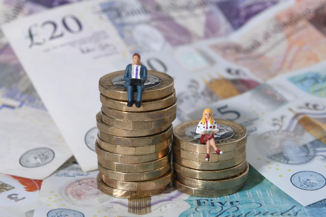 Models of a man and woman stand on a pile of coins and bank notes. Photo: Joe Giddens/PA Archive/PA Images