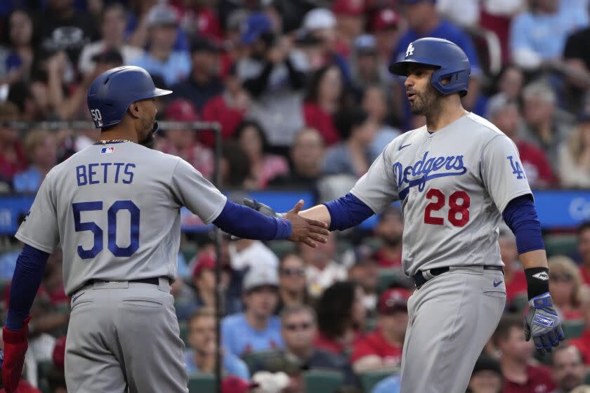 Los Angeles Dodgers' J.D. Martinez is congratulated by teammate Mookie Betts (50) after hitting a three-run home run.