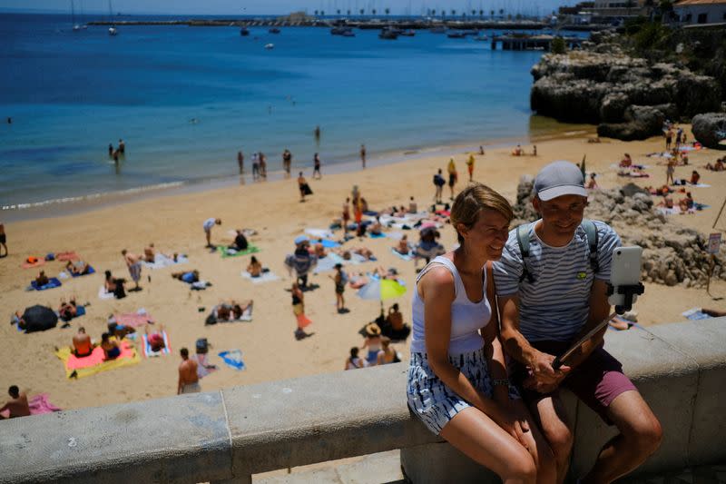 FILE PHOTO: Tourists take a photo near a beach in Cascais