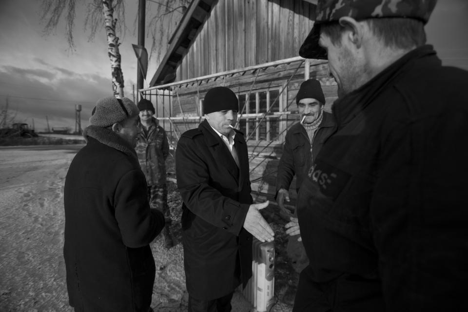 In this Nov. 14, 2012, photo, Eduard Mochalov, center, greets former employees of his agricultural concern in Yarabaikasy near Cheboksary, the capital city of Chuvashia, Russia. Mochalov has found a new lease on life as a crusading journalist investigating corruption in his native region, fueled by tips from disgruntled businessmen and government workers. Undeterred by a system where the law is selectively used to protect the powerful and crack down on critics, Mochalov has quickly earned cult status _ not to mention the ire of countless local officials _ throughout the small province of Chuvashia. (AP Photo/Alexander Zemlianichenko)