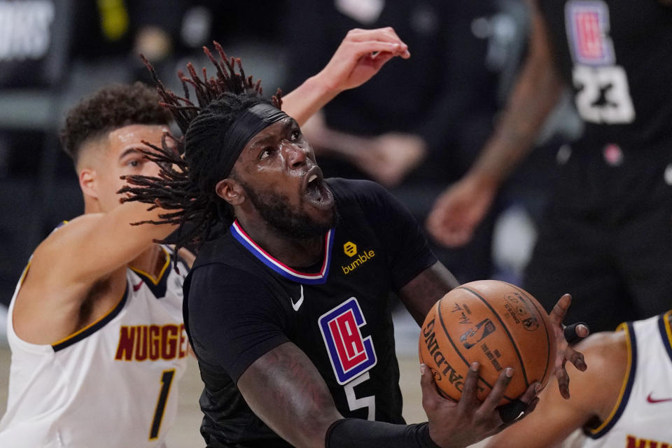 Los Angeles Clippers' Montrezl Harrell (5) drives to the basket past Denver Nuggets' Michael Porter Jr. (1) in the second half of an NBA conference semifinal playoff basketball game Thursday, Sept 3, 2020, in Lake Buena Vista Fla. (AP Photo/Mark J. Terrill)