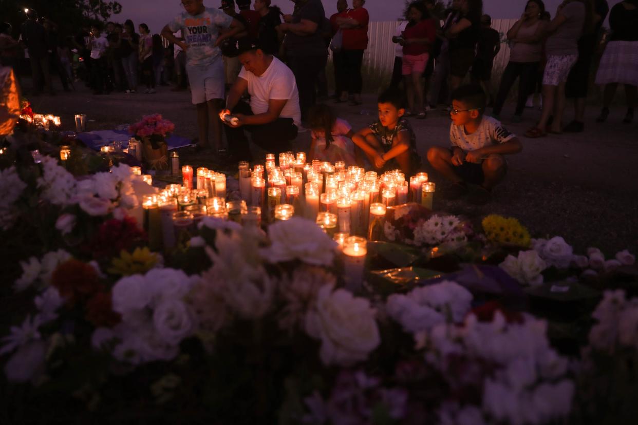 Children sit and look over dozens of candles at a memorial site in San Antonio dedicated to 53 migrants that died of heat-related illness in an abandoned semitrailer in June.
(Photo: Aaron E. Martinez / American-Statesman)