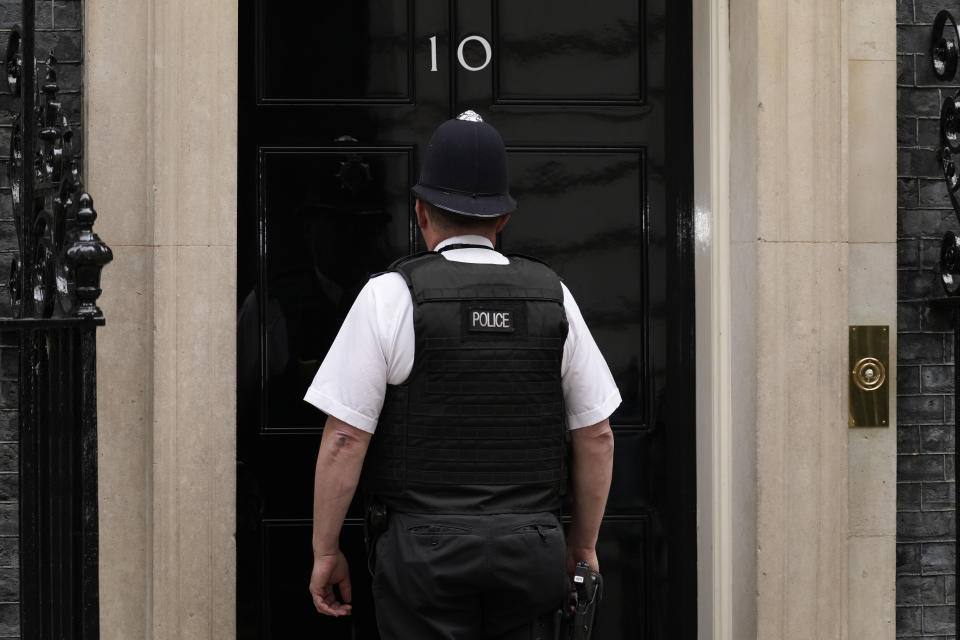 A police officer goes into 10 Downing Street, in London, Wednesday, May 25, 2022. British Prime Minister Johnson is awaiting a senior civil servant's report into lockdown-breaking government parties that could further weaken his grip on power. The results of senior civil servant Sue Gray's investigation of the "partygate" scandal could come as soon as Wednesday, and will pile more pressure on the prime minister. (AP Photo/Matt Dunham)