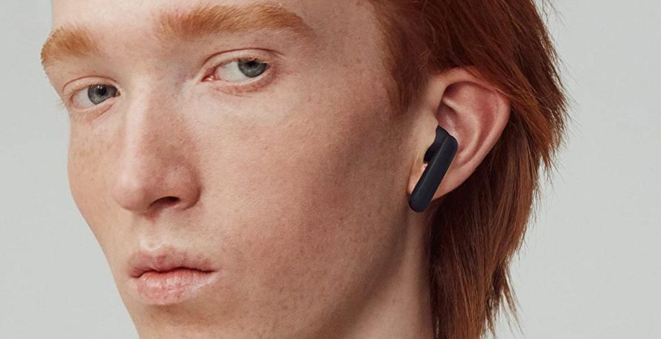 a man wearing the urbanears alby wireless earbuds in black