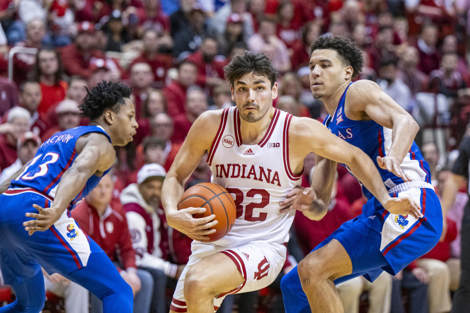 Indiana guard Trey Galloway (32) drives around the defense of Kansas guard Kevin McCullar Jr., right, en route to the basket during the second half of an NCAA college basketball game, Saturday, Dec. 16, 2023, in Bloomington, Ind. (AP Photo/Doug McSchooler)