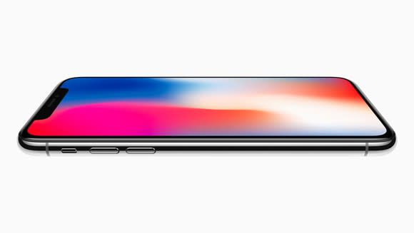 A space gray iPhone X lying on an invisible flat surface.