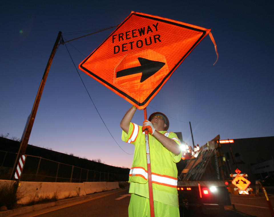 A construction worker installs a sign to close the ramp of Interstate 405 freeway at Santa Monica Boulevard on July 15, 2011 in Los Angeles. A 10-mile stretch of the Interstate 405 Freeway will be closed for construction from July 16-18 for 53 hours between two of the nation's busiest interchanges. Los Angeles city officials are advising residents to stay home or stay away from the area over the weekend fearing massive traffic jams of what has become known as 'Carmageddon.' (AP Photo/Ringo H.W. Chiu)