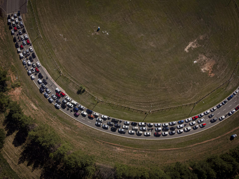 Drivers wait to undergo a free PCR COVID test at a drive-thru testing site on a racetrack in Capiata, Paraguay, Tuesday, Jan. 11, 2022. (AP Photo/Jorge Saenz)