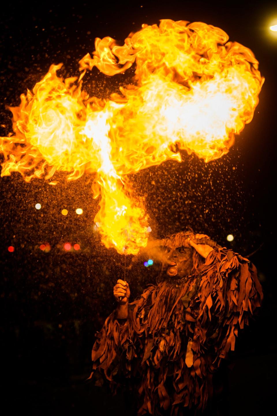 A Krampus shoots a fireball during the Krampus Ramage & Bazaar on Dec. 4, 2021 in downtown Bloomington.