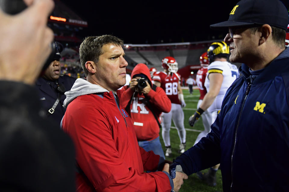 Head coach Chris Ash (L) of the Rutgers Scarlet Knights shakes hands with head coach Jim Harbaugh of the Michigan Wolverines after the game Saturday. Michigan won 42-7. (Getty Images)