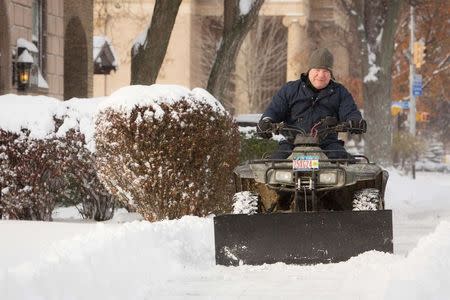 A man plows snow off his sidewalk in Buffalo, New York, November 19, 2014. REUTERS/Lindsay DeDario