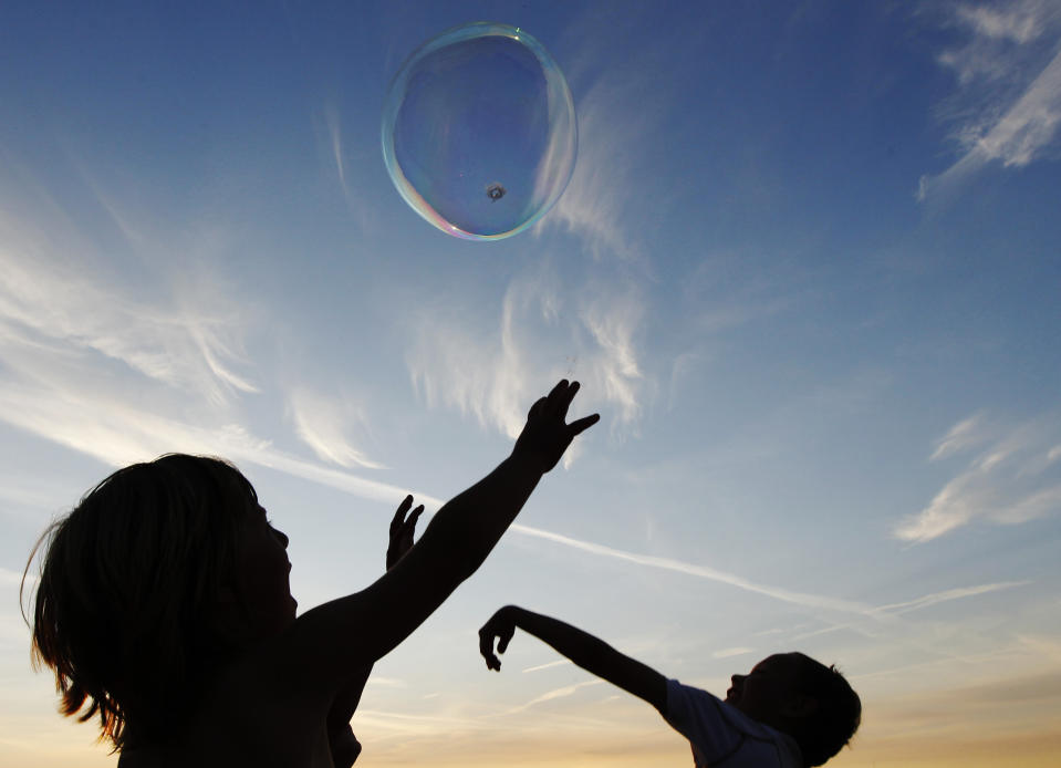 Children play with giant bubbles at the Glastonbury Festival 2010 in south west England, June 23, 2010. Picture taken June 23, 2010. REUTERS/Luke MacGregor (BRITAIN - Tags: ENTERTAINMENT SOCIETY)