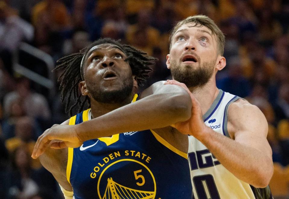 Golden State Warriors forward Kevon Looney (5) and Sacramento Kings center Domantas Sabonis look for a rebound during Game 6 of the first-round NBA playoff series at Chase Center on Friday.
