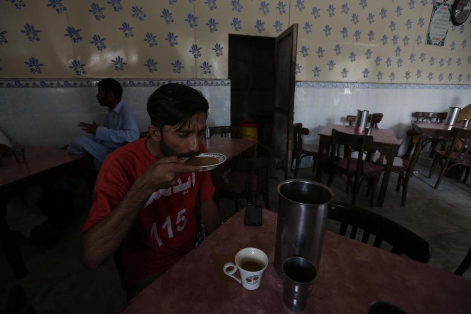 The tea shop near to the office brews vats of traditional masala chai (Akhtar Soomro/Reuters)