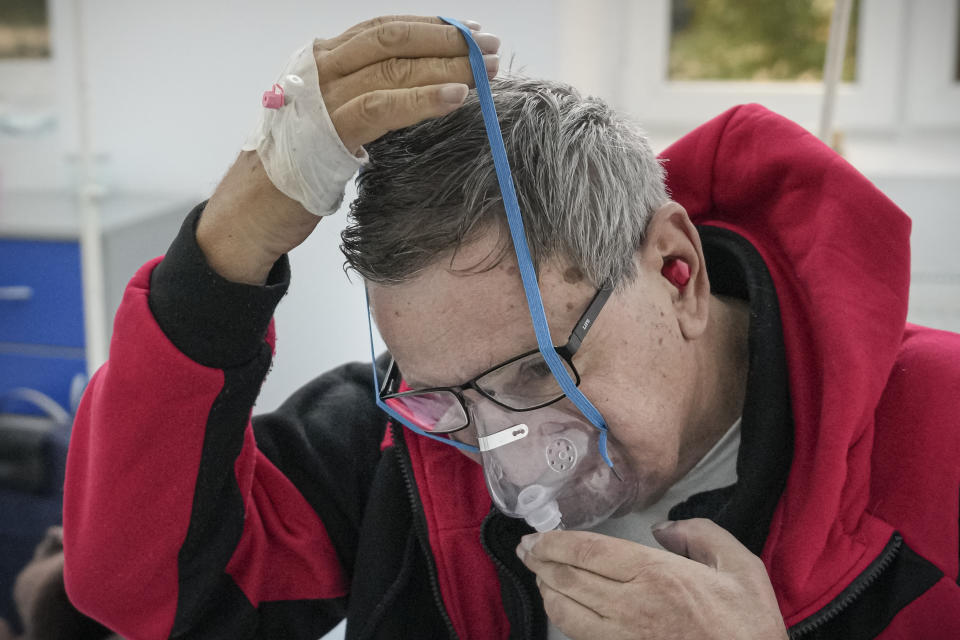 Florin Sandu, 72 years-old, places an oxygen mask on his face at the COVID-19 unit of the Marius Nasta National Pneumology Institute in Bucharest, Romania, Thursday, Sept. 23, 2021. Daily new coronavirus infections in Romania, a country of 19 million, have grown exponentially over the last month, while vaccine uptake has declined to worrying lows. Government data shows that 91.5% of COVID-19 deaths in Romania between Sept. 18-23 were people who had not been vaccinated. (AP Photo/Vadim Ghirda)