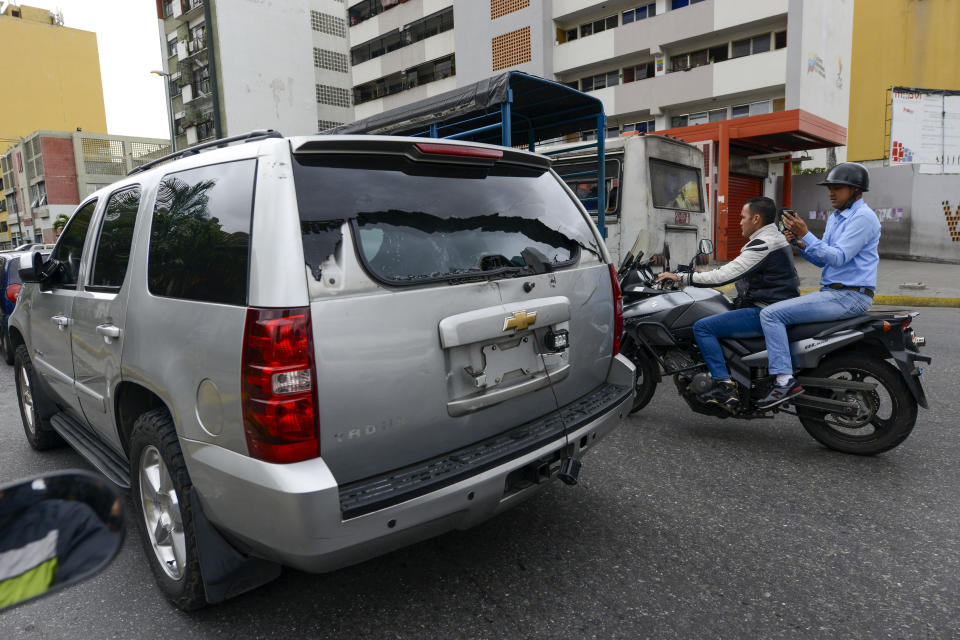 Un vehículo que transportaba a legisladores de la oposición se aleja después de que partidarios del gobierno le arrojaron piedras y rompieron su ventana trasera cuando se dirigía a una sesión de la Asamblea Nacional en Caracas, Venezuela, el miércoles 15 de enero de 2020. (AP Foto / Matias Delacroix )