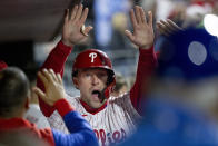 Philadelphia Phillies' Rhys Hoskins is cheered in the dugout after scoring on an RBI double by Didi Gregorius during the eighth inning of a baseball game against the New York Mets, Monday, April 11, 2022, in Philadelphia. (AP Photo/Laurence Kesterson)