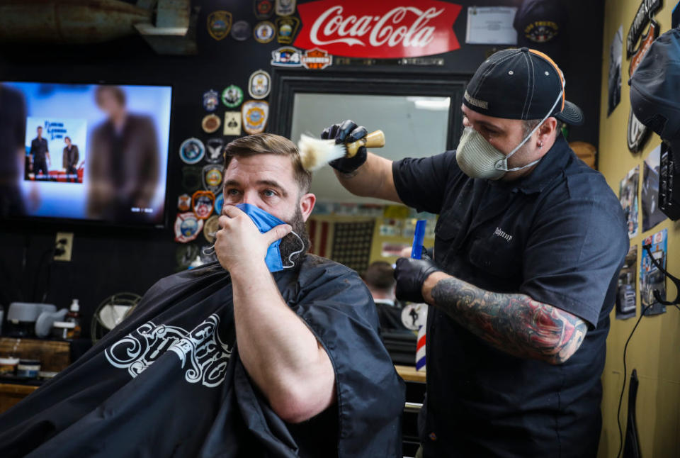 Rusty Razor Barber Shop co-owner John Hopping cuts Norman Bettencourt's hair on the first day of reopening since the coronavirus shutdowns over one month prior in Kittery, ME on May 1, 2020. | Erin Clark/The Boston Globe—Getty Images