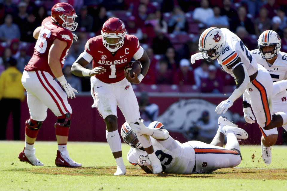 Arkansas quarterback KJ Jefferson (1) slips past Auburn defenders J.J. Pegues (89) and Derick Hall (29) as he runs the ball during the first half of an NCAA college football game Saturday, Oct. 16, 2021, in Fayetteville, Ark. (AP Photo/Michael Woods)