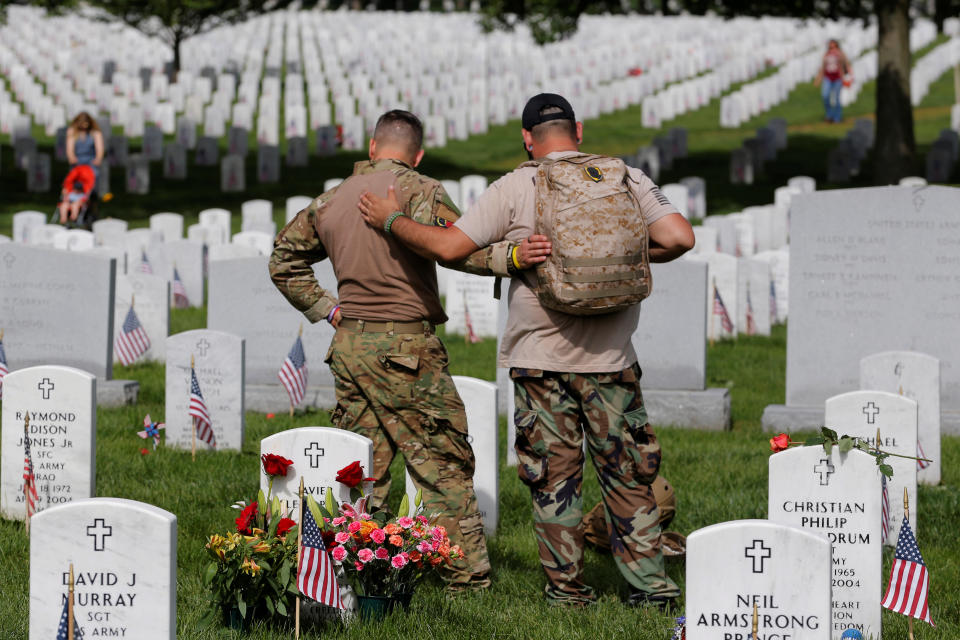 U.S. Army soldiers Rick Kolberg, left, &nbsp;and Jesus Gallegos embrace as they visit the graves of Raymond Jones and Peter Enos on Memorial Day at Arlington National Cemetery in Washington on May 30, 2016.&nbsp;