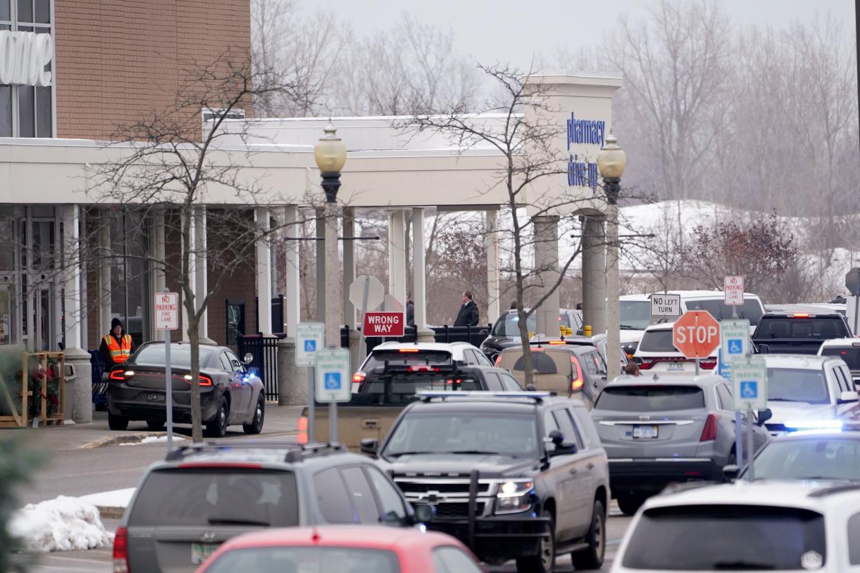 Police are shown in the parking lot of a Meijer store where Oxford High School students were being reunited with parents in Oxford, Mich., Tuesday, Nov. 30, 2021. Authorities say a 15-year-old sophomore opened fire at Oxford High School, killing several students and wounding multiple other people, including a teacher.