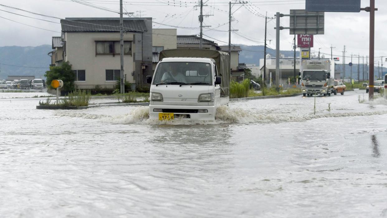 Eine Straße in Tachiarai in der Präfektur Fukuoka im Südwesten Japans steht nach starken Regenfälle unter Wasser. Foto: Kyodo/dpa