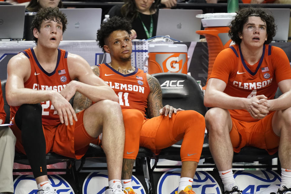 Clemson's PJ Hall (24), Brevin Galloway (11) and Ian Schieffelin (4) watch the final minutes of their loss to Virginia in an NCAA college basketball game at the Atlantic Coast Conference Tournament in Greensboro, N.C., Friday, March 10, 2023. (AP Photo/Chuck Burton)