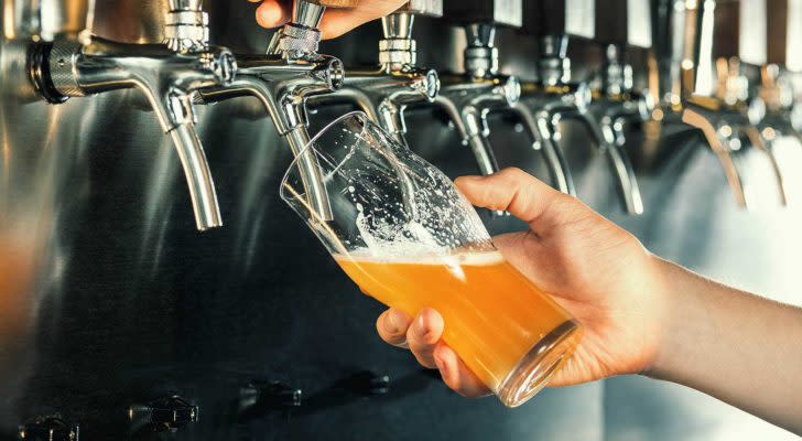 A photo of a person pouring a beer from a tap.