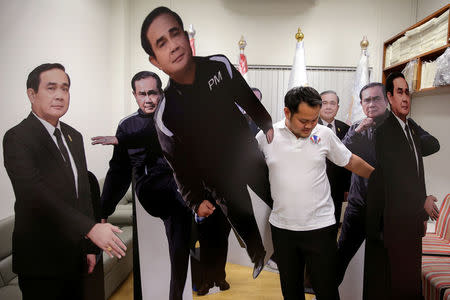 A government official arranges cardboard cut-outs of Thailand's Prime Minister Prayuth Chan-ocha at Government House in Bangkok, Thailand, January 9, 2018. REUTERS/Athit Perawongmetha