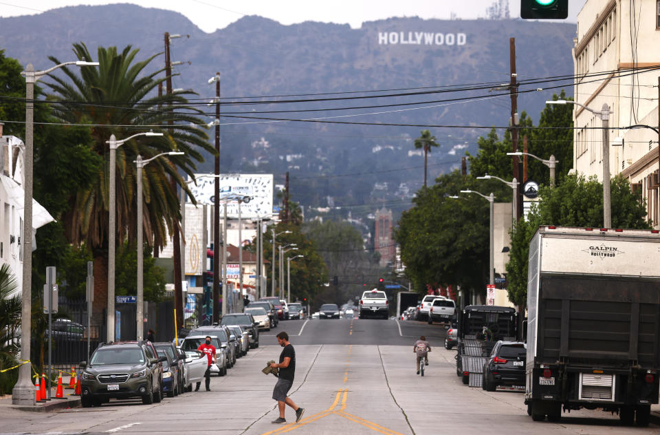 A man walks across the middle of a street.