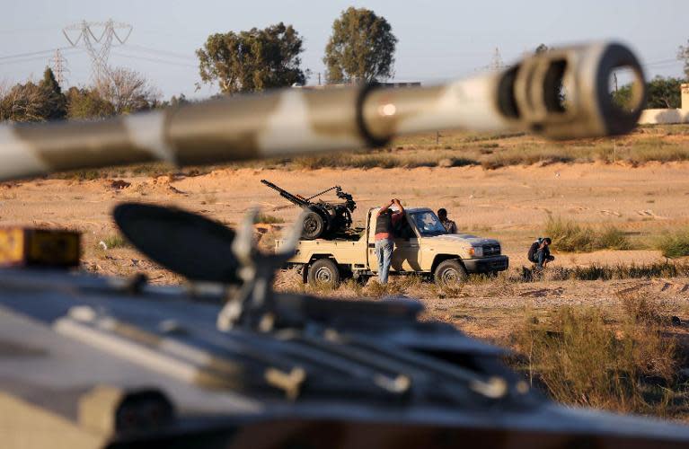 Members of the Tripoli Rebels Brigade militia patrol a main road in Tajura, 15 kms from the capital Tripoli, on November 16, 2013, after foiling attempts by Misrata-based militiamen to advance into the city earlier in the day