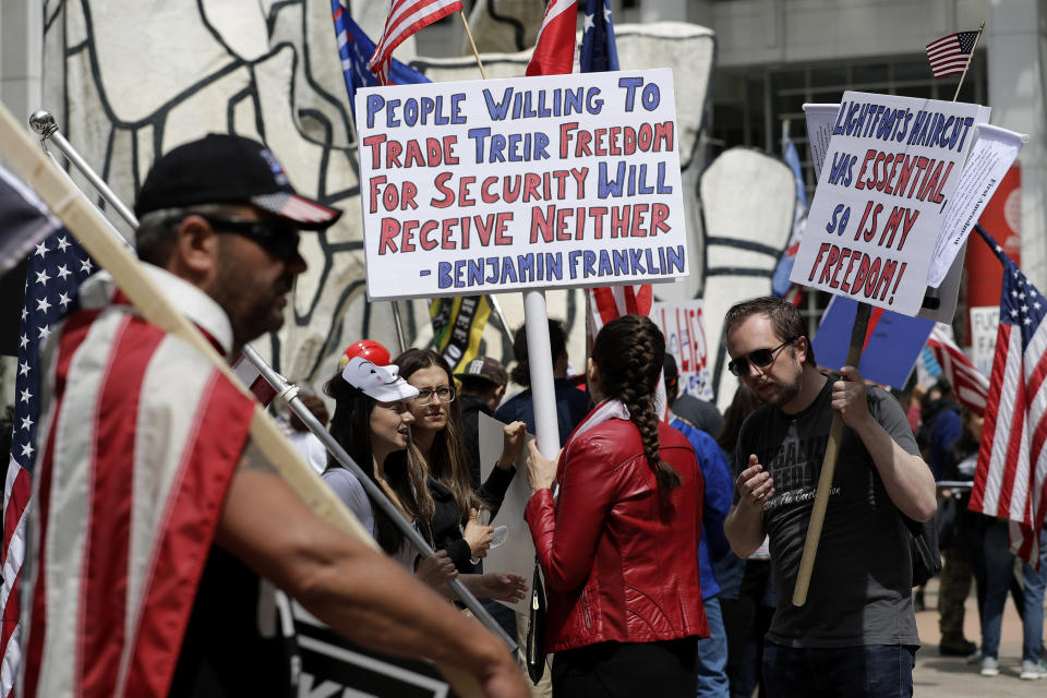 "La gente que está dispuesta a sacrificar su libertad por seguridad no tendrá ninguna de las dos", dice un cartel de una manifestación para protestar los confinamientos del coronavirus en Chicago el 16 de mayo del 2020. (AP Photo/Nam Y. Huh, File)