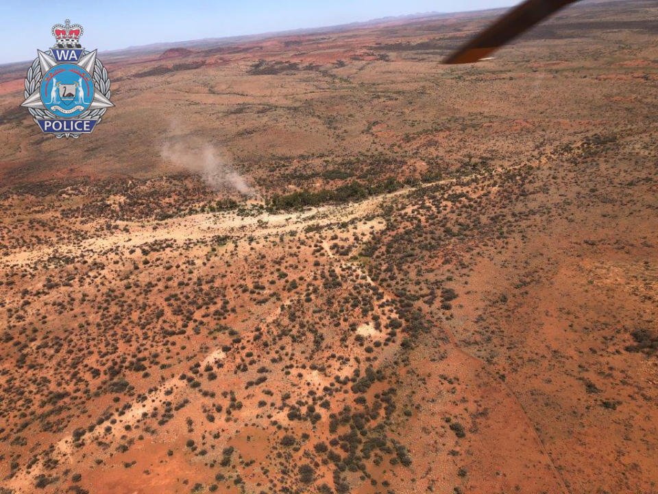 An aerial view of the WA man's makeshift campsite with smoke billowing into the air.