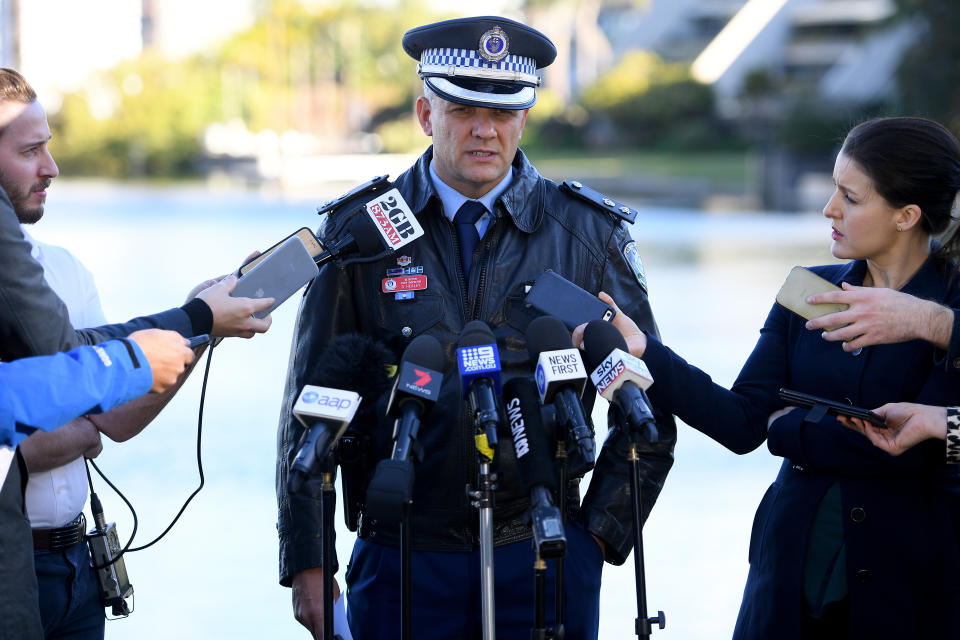 Detective Acting Superintendent Grant Healey speaks to a group of journalists. 